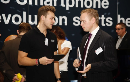 Joël Egberink in gesprek met een Sony medewerker op een beurs in Duitsland.